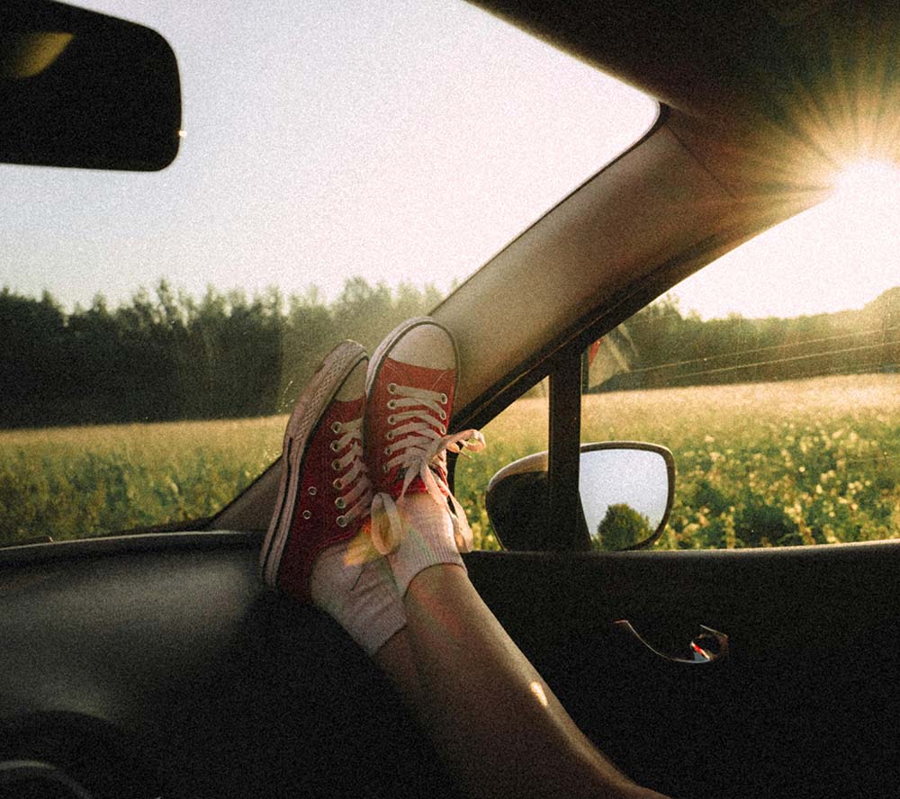 Converse shoes on the dashboard of a car