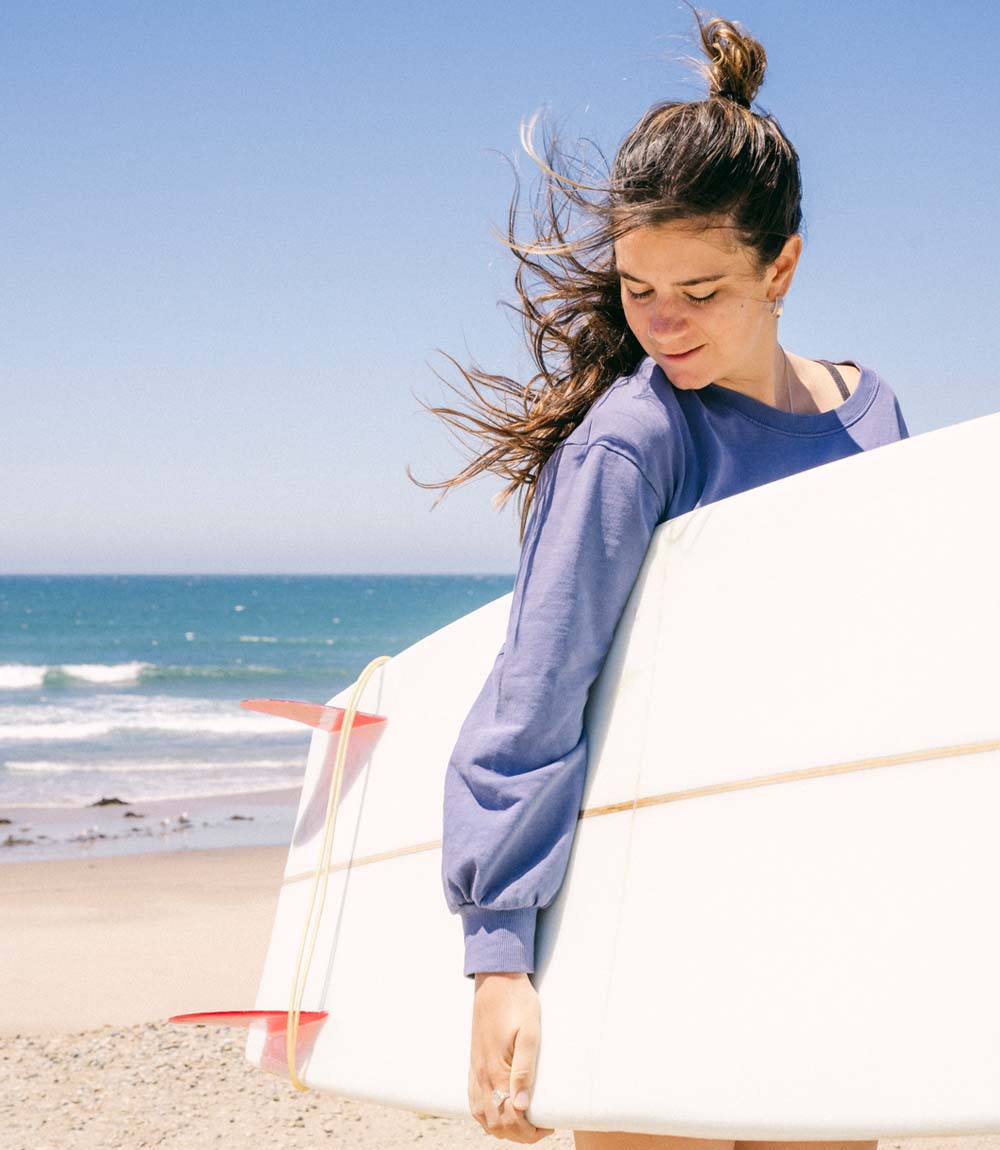 woman holding a surfboard at the beach in California